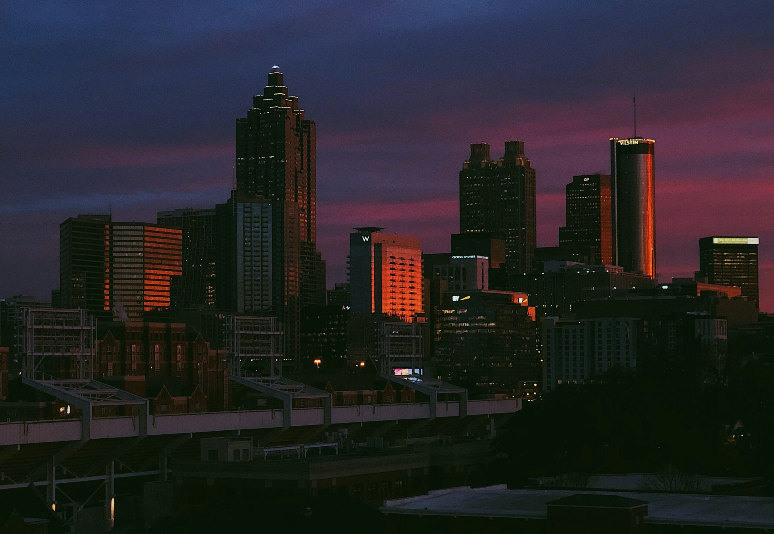 “Atlanta skyline at sunset—including Bank of America Plaza and Midtown high‑rises—symbolizing Delrecruiters’ supply‑chain staffing services for warehouses and logistics operations across Metro Atlanta
