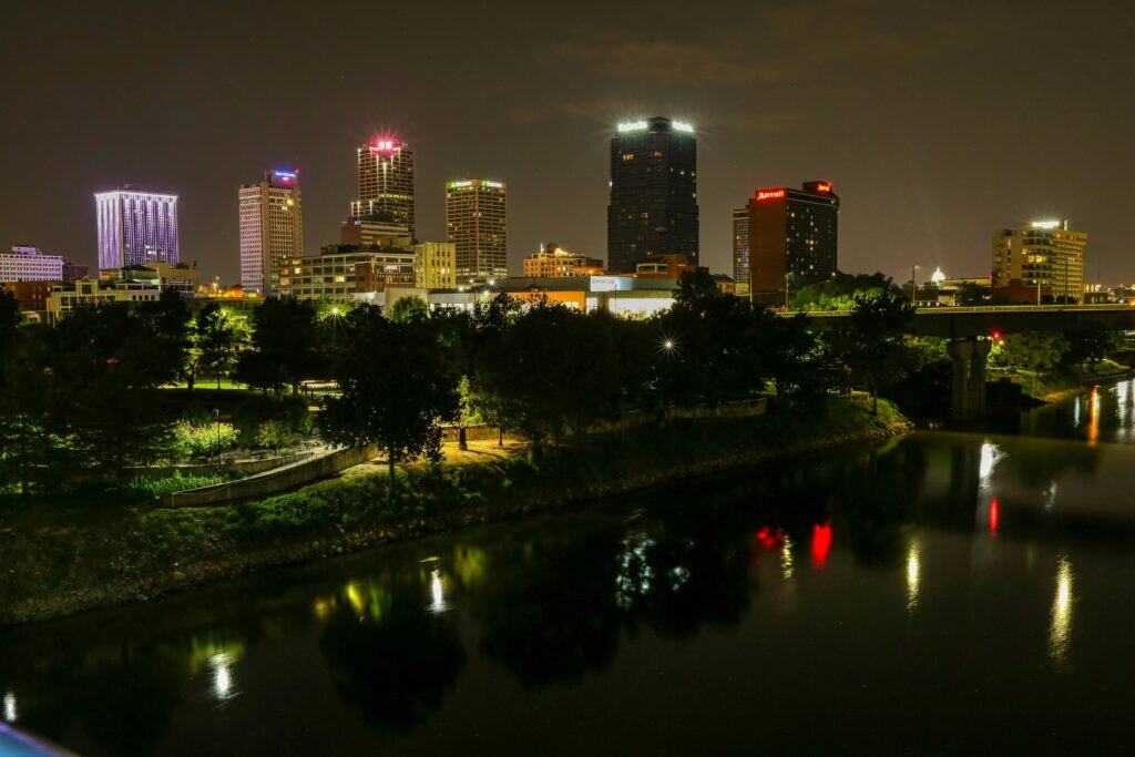 Downtown Little Rock skyline at night reflecting on the Arkansas River, representing Delrecruiters’ commitment to supply chain staffing excellence in the region